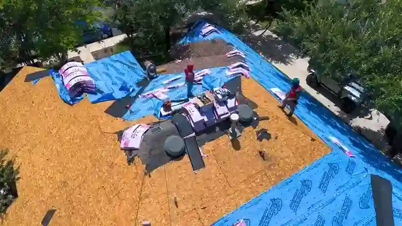 Aerial view of a Nestled Roofing crew installing new underlayment on a San Antonio home